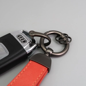 Detailed close-up of red suede car keychain strap with matte gunmetal D-ring hardware