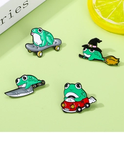 Detailed view of four green frog enamel pins featuring skateboard and car designs