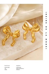 Detail of 18K gold plated bow earrings with wrinkled texture on white stone and silk