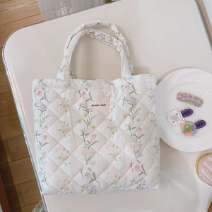 Detail of quilted floral tote bag with tulip patterns and simple wish woven label