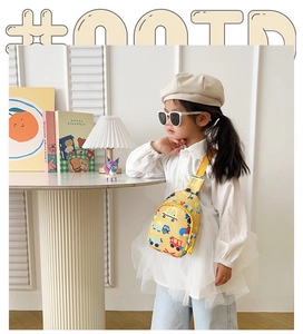 Detailed view of yellow kids chest bag with colorful construction vehicle patterns