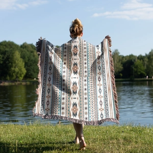 Close-up of bohemian picnic blanket with geometric patterns and colorful tassel edges