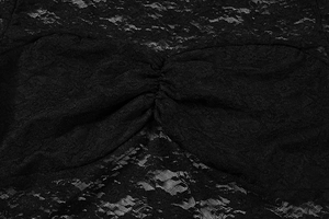 Gros plan des fronces et de la dentelle semi-transparente sur une robe noire chic