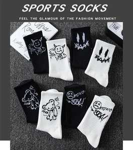 Detail of cotton crew sports socks with black and white graffiti bear and devil prints