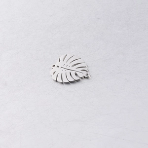 Macro view of mirror-finish stainless steel monstera leaf pendant with hollow design