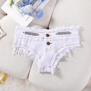 Dettaglio degli shorts di jeans bianchi con decorazioni in strass e bordi sfilacciati