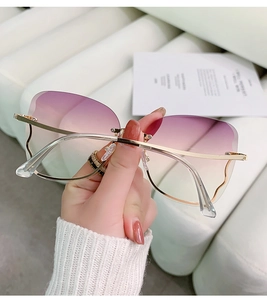 Detail of rimless gradient purple lenses with golden metal wave temples and nose bridge