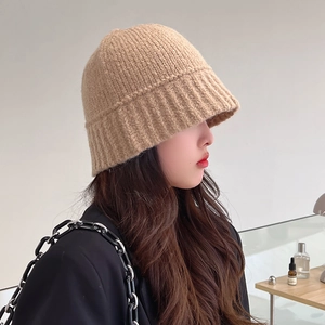 Fashionable beige knitted bucket hat for women showing a cozy winter style profile view