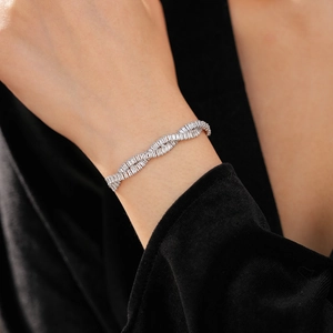 Gros plan d'un bracelet torsadé en argent serti de zircons et de cristaux taille baguette