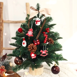 Mini tabletop Christmas tree with wool ornaments, pine cones, and LED lights on wood base