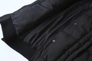Dettaglio di un gilet nero imbottito con zip di alta qualità e chiusura a bottoni a pressione
