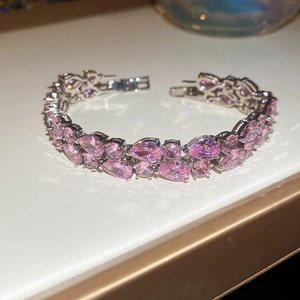 Close-up of sparkling pink pear-cut zircon stones set in a silver clasp bracelet