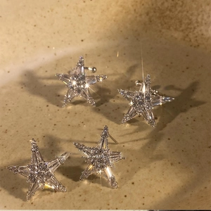 Macro detail of silver starfish stud earrings with shiny cubic zirconia stones