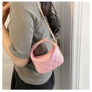 Pink quilted mini chain bag with gold hardware worn by a model to show size and texture