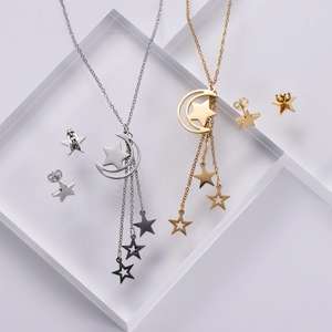 Detail view of gold and silver moon star pendant necklaces with tassel star charms