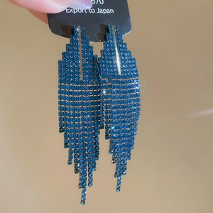 Détail de boucles d'oreilles à pampilles en strass bleu foncé avec design géométrique