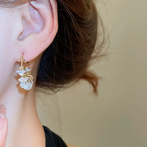 Close-up of 18k gold plated crystal geometric hoop earrings on female model