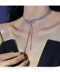 Close-up of sparkling silver bow choker with dangling rhinestone tassels on a model