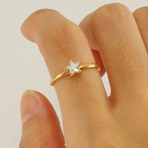 Minimalist gold stainless steel ring featuring a star-shaped zircon stone on model's finger