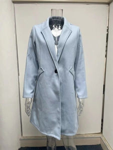 Detailed view of light blue mid-length wool coat with black buttons on a mannequin