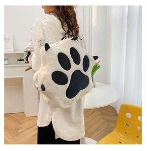 Detail showing plush white cat paw backpack with black paw prints on the back of a model