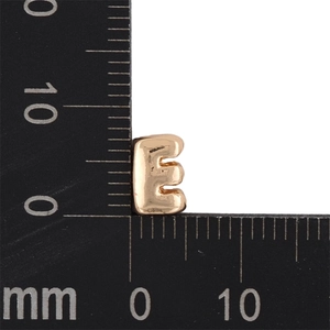 Macro scale measurement of a 7mm x 6mm gold-toned bubble letter E jewelry pendant