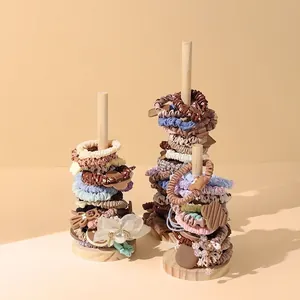 Solid wood stand showcasing various Morandi-colored elastic hair ties and scrunchies