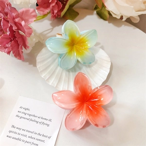 Détail de pinces à cheveux plumeria dégradées au design floral bleu-jaune et rose-orange