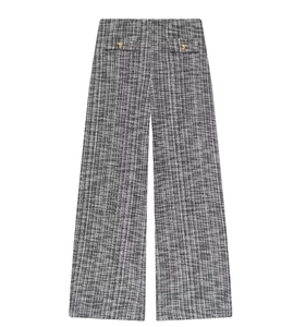 Détail d'un pantalon large en tweed avec texture tissée et boutons dorés décoratifs