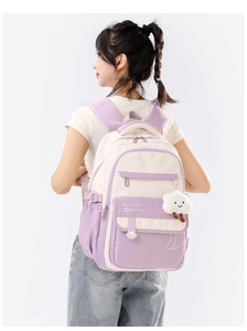 Girl wearing a purple and beige ergonomic backpack with a cute white cloud pendant