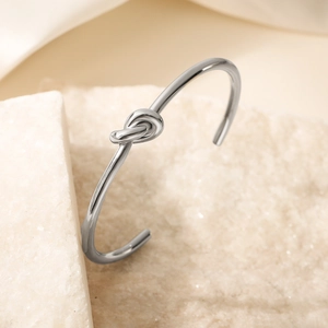 Bracelet jonc ouvert en acier inoxydable argenté poli avec un détail de nœud