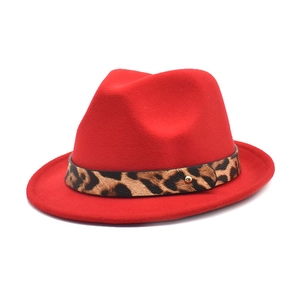 Close-up of red wool felt fedora hat with leopard print band and gold stud details