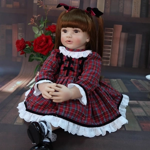 60cm reborn toddler doll with brown pigtails in a red plaid dress sitting in a library