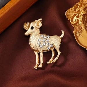 Vintage golden Aries ram brooch with sparkling rhinestones on luxury silk background