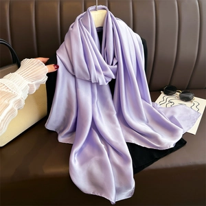Close-up of lavender silk scarf with smooth texture draped on a hanger with fashion accessories