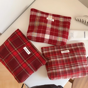 Trois trousses à maquillage en laine à carreaux rouges avec étiquette tissée logo
