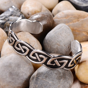 Vintage stainless steel Viking Celtic knot open cuff bracelet on a natural stone background