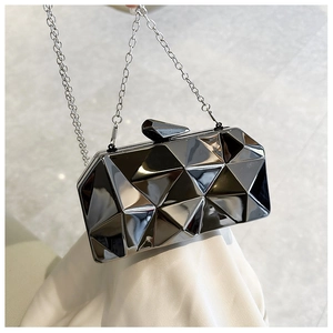 Detailed macro view of 3D geometric faceted grey acrylic clutch bag with silver chain