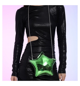 Close-up of a glossy green star-shaped evening clutch bag held by a model in a snakeskin dress