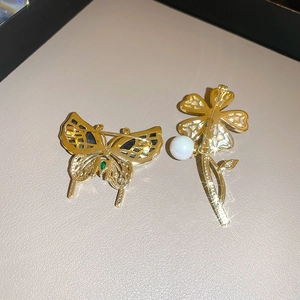 Détail de la broche papillon plaquée or avec motif ajouré et épingle de fixation arrière