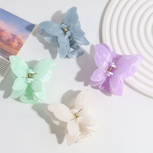 Detailed close-up of four gradient marble-textured butterfly hair claws in pastel tones