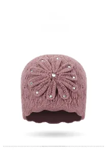 Detailopname van handgebreide bloem en strass-steentjes op een warme wintermuts