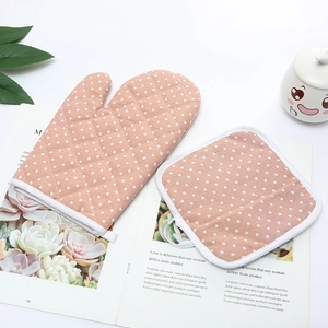 Kitchen oven mitt and pot holder set with white polka dots on pink cotton quilting