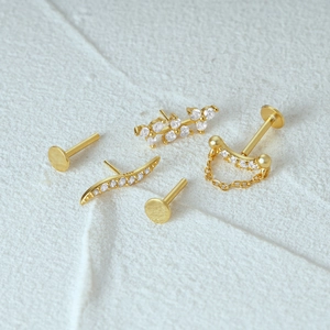 Macro-opname van vijf vergulde S925 zilveren studs met blad- en kwastontwerpen