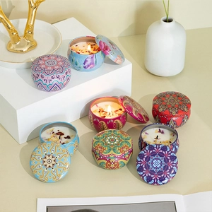 Detail showing tin soy candles with colorful mandala patterns and dried flower petals