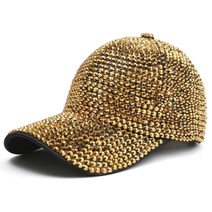 Hip hop style gold baseball cap with metallic cone studs and curved brim on white background