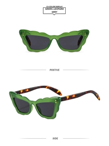 Detail of green wavy frame cat eye sunglasses with tortoise temples and grey lenses