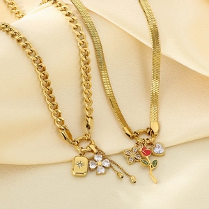 Close-up of gold stainless steel snake chain with red rose and heart zircon pendants