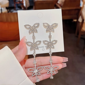 Detail of silver butterfly tassel earrings with sparkling crystals and drop pendants
