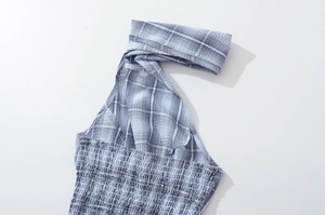 Detail of blue plaid halter top featuring smocked elastic texture and seersucker fabric